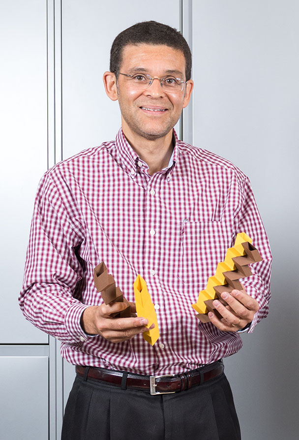 Glaucio Paulino with two of the paper models that demonstrate a new "zippered-tube" origami configuration he has developed. Paulino has been named a fellow of the American Society of Civil Engineers Engineering Mechanics Institute. (File Photo: Rob Felt)