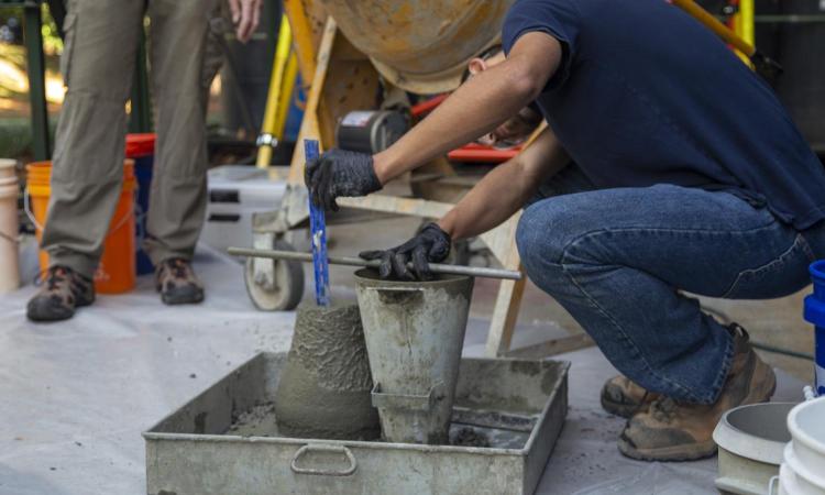 A man pouring concrete into a mold