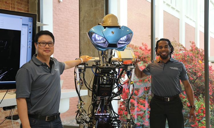Associate Professor Yong Cho and Dimitri Seneca Snowden with the robot Snowden has donated to Cho's research lab.