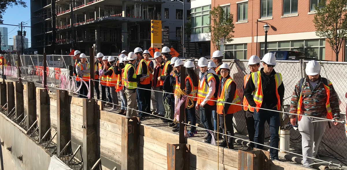 people in protective vests and hard hats at a construction site
